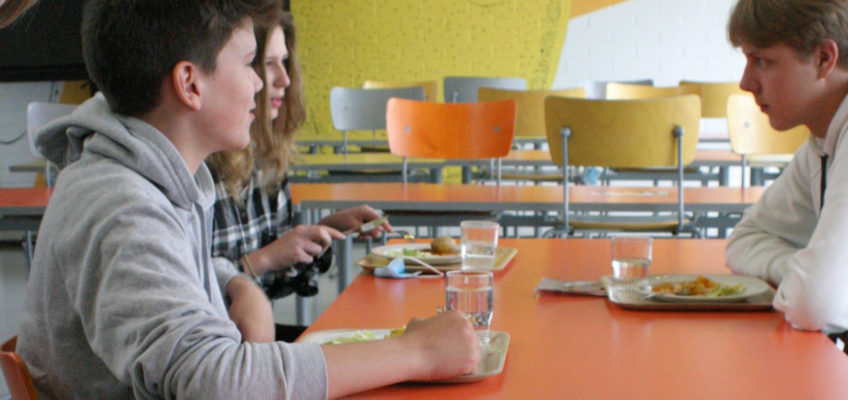 Yläkoulun oppilaita syömässä