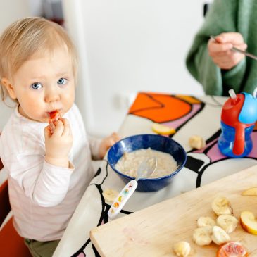 2-vuotias syö hedelmää ruokapöydässä