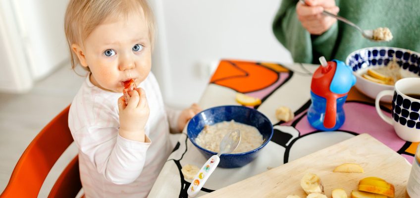 2-vuotias syö hedelmää ruokapöydässä