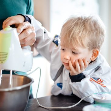 Pieni lapsi käyttää sähkövatkainta yhdessä vanhempansa kanssa.